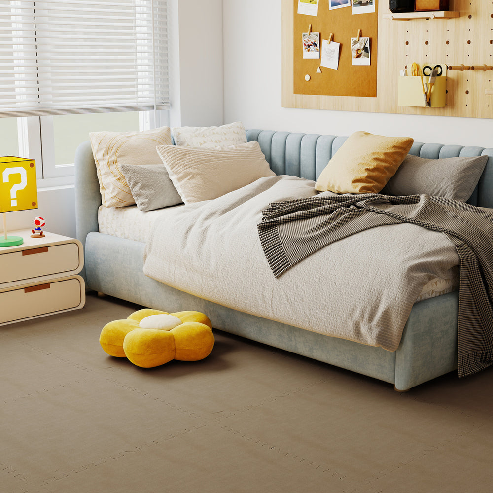 Beige interlocking foam floor tiles with edge borders, providing cushioning and noise reduction for living spaces.