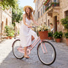 26-inch pink beach cruiser bike for women with a woven basket, ergonomic seat, and rear rack, perfect for leisurely.