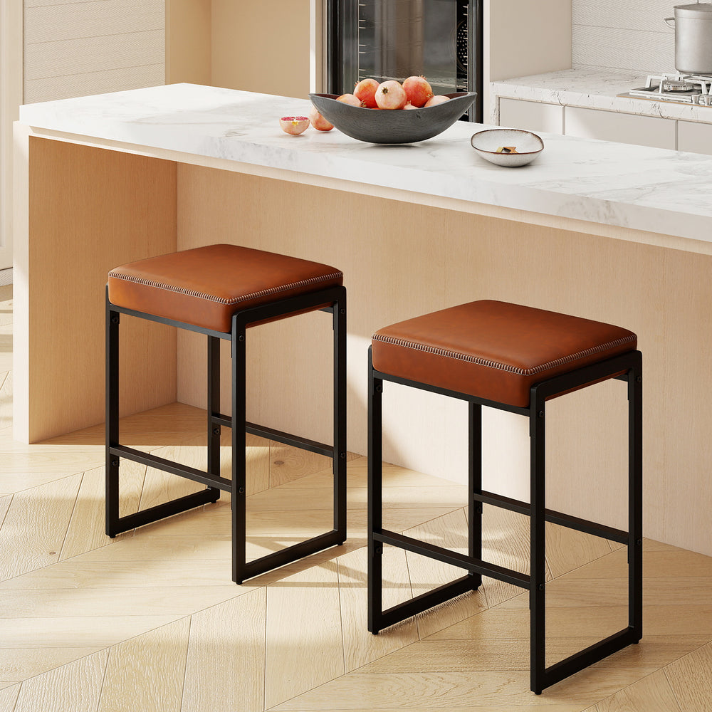 Set of two 26-inch brown bar stools with faux leather seats and sturdy metal frames, perfect for kitchen counters.