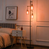 Retro floor lamp with three amber glass shades, stable iron base, ideal for bedroom or living room lighting.