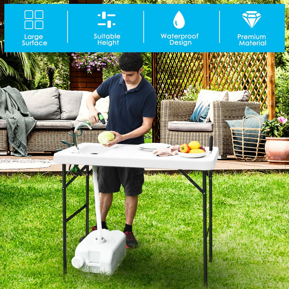 Folding cleaning sink table with sprayer, sturdy plastic surface, ideal for outdoor cleaning and potting tasks.