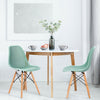 Modern green plastic hollow chair set with wood legs, featuring ergonomic design for dining room or office use.