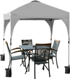 View of the 6.6 x 6.6 FT white pop-up canopy tent set up, providing ample shade over a table and chairs for outdoor.