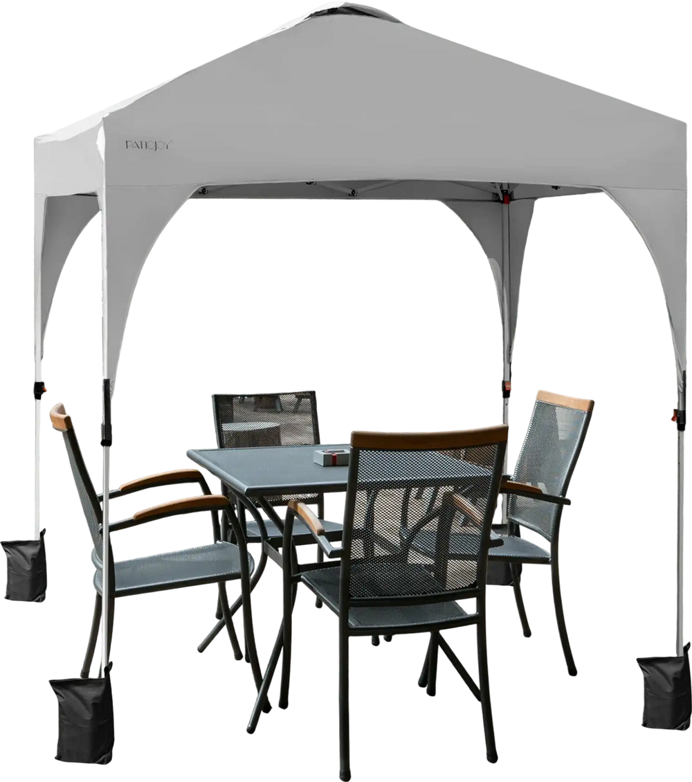 View of the 6.6 x 6.6 FT white pop-up canopy tent set up, providing ample shade over a table and chairs for outdoor.