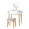 Wooden makeup dressing table set with round mirror, drawer, and cushioned stool for stylish home decor.