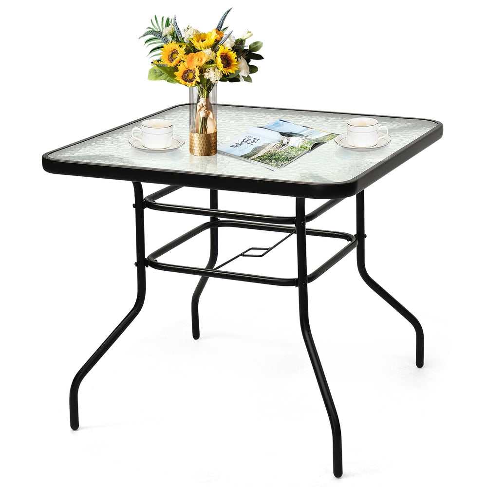 Black steel square table with tempered glass top, perfect for outdoor dining and umbrella support in patio or garden.