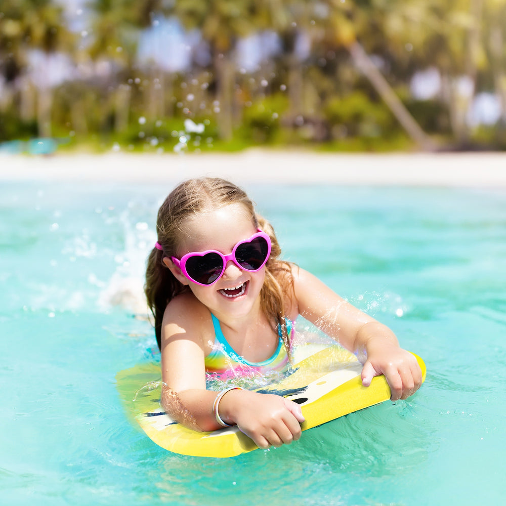 Child enjoying the Lightweight Super Surfing Bodyboard in the water, featuring a bright yellow design and strong.