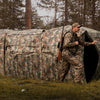 Hunting blind with camouflage pattern, featuring one-way see-through panels and adjustable windows for stealthy.