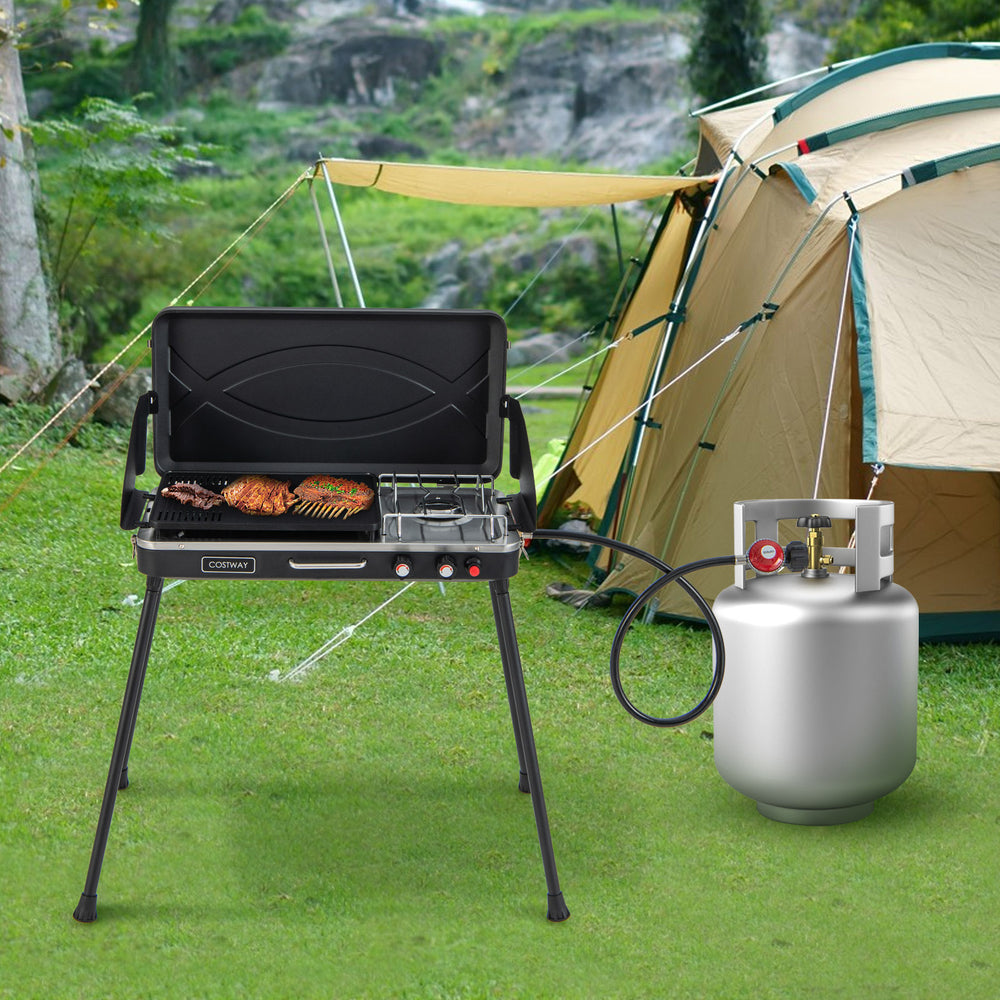 Portable 2-in-1 gas camping grill and stove with detachable legs, featuring a wind-block design for outdoor cooking.