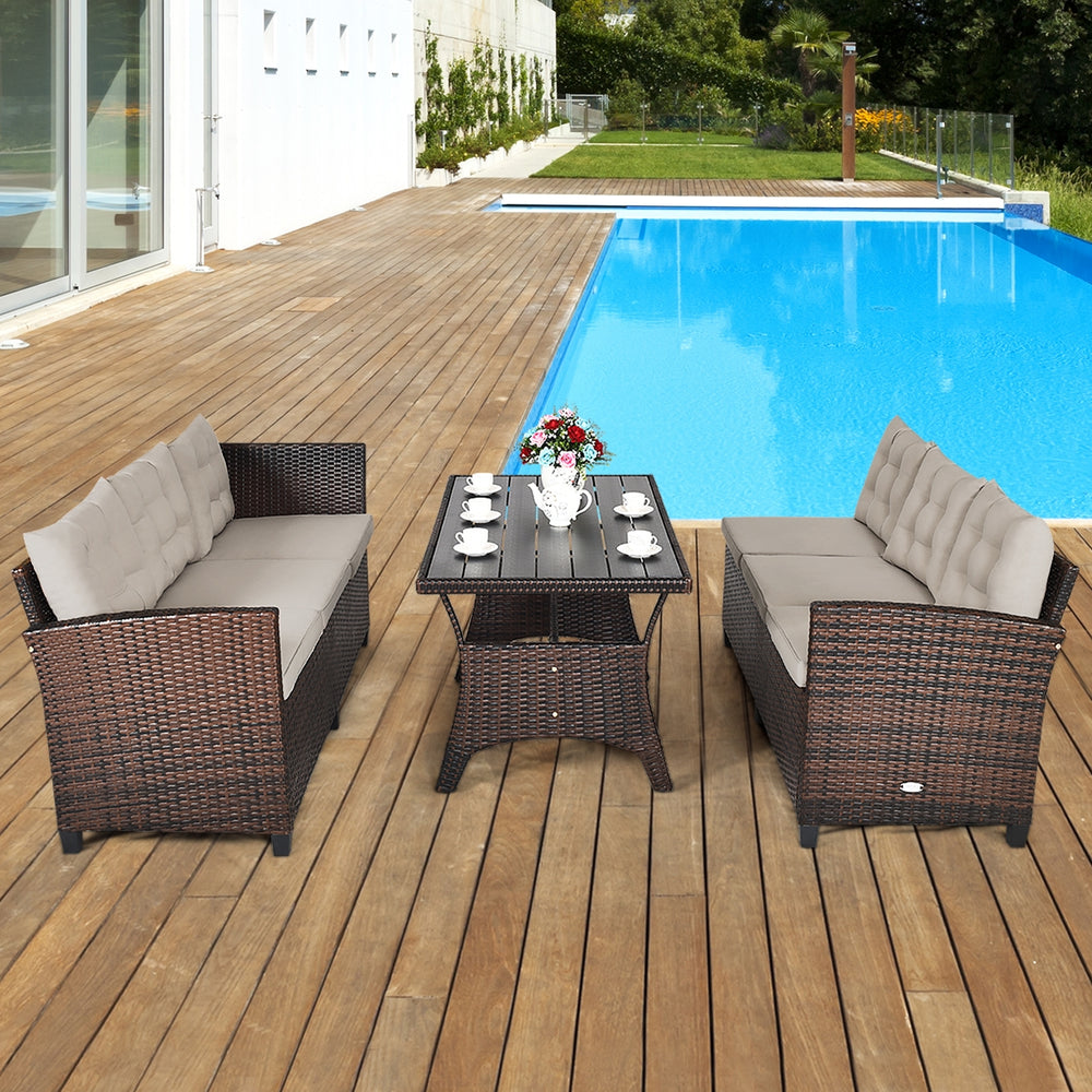 Three-piece hand-woven rattan outdoor sofa set with dining table, featuring soft cushions, ideal for poolside.