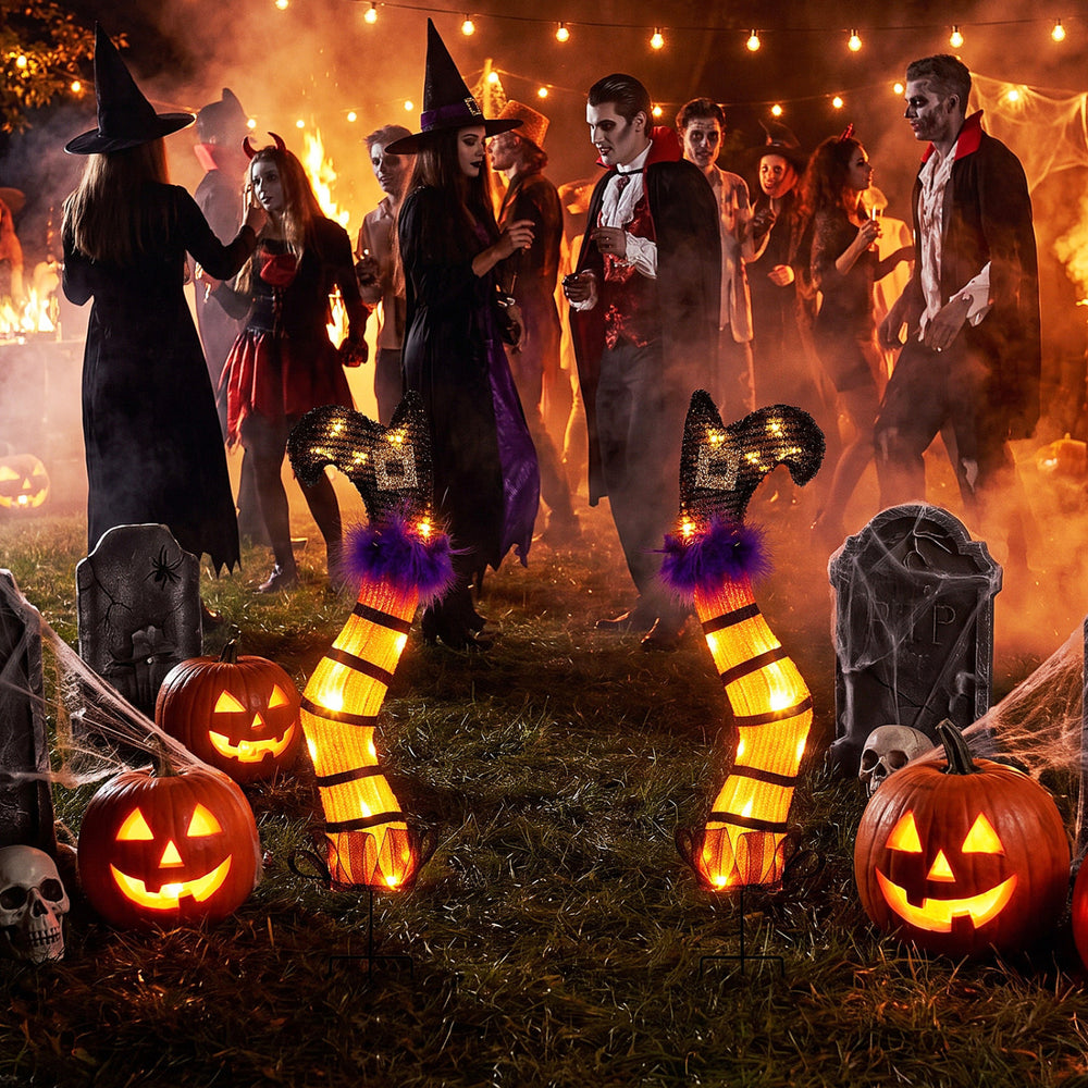 Set of 2 lighted witch legs with purple trim and 30 warm white LEDs, perfect for Halloween indoor and outdoor displays.