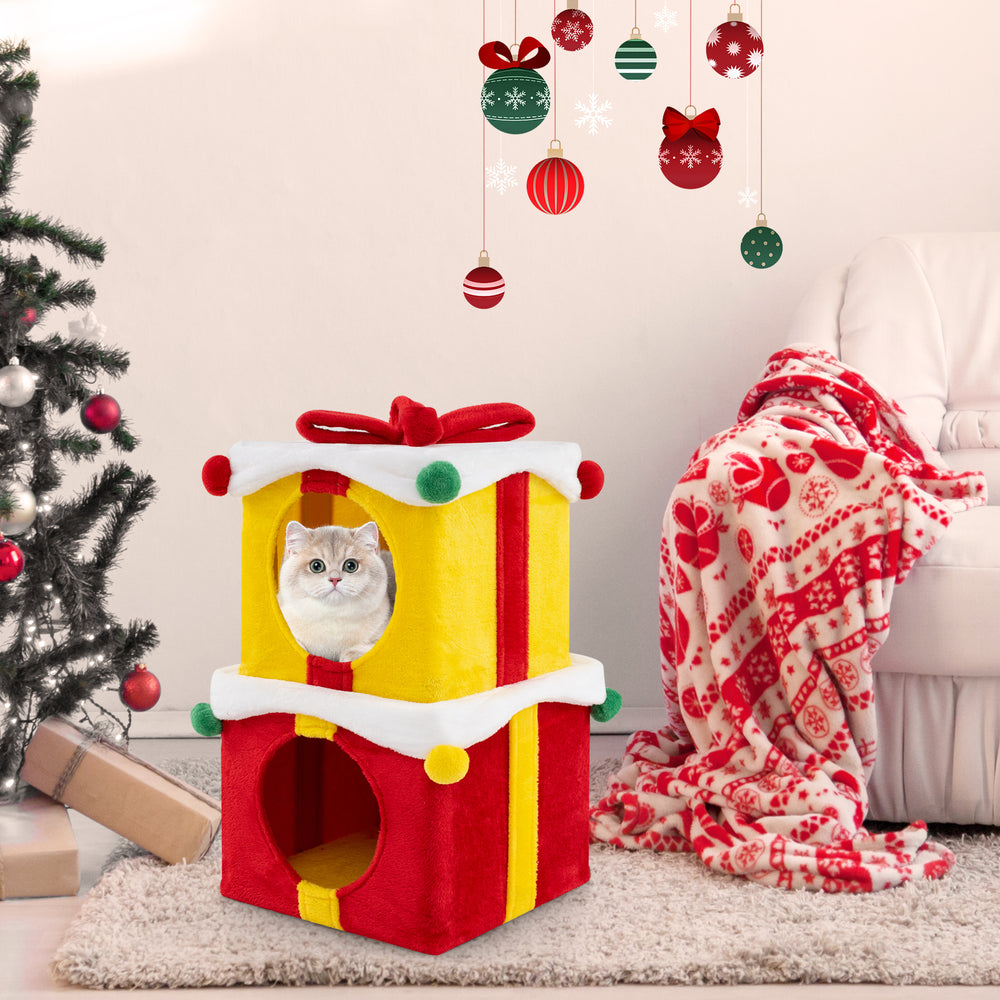 Gift box shaped Christmas cat house in multicolor with stacked condos, red bow, and plush covering for festive feline.