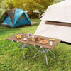 Folding camping table with wood-grain tabletop, set for outdoor dining, ideal for hiking, picnics, or BBQs.
