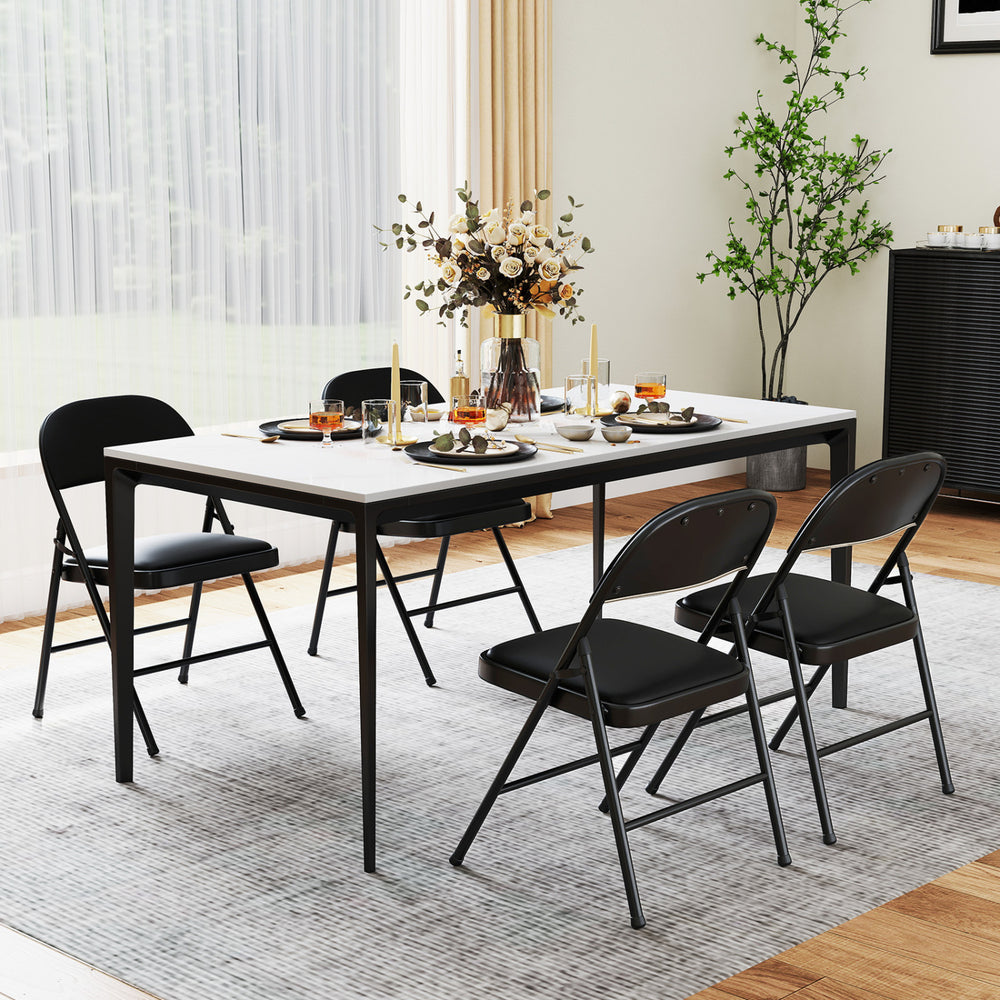 Black folding chairs with metal frame and PVC leather, featuring curved backrest, set for indoor dining or events.
