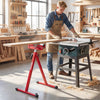 Folding roller stand in red with adjustable height, supporting lumber feeding in a workshop setting.