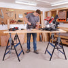 Heavy-duty metal folding saw horses in blue with adjustable height, ideal for contractors and DIY projects in workshops.