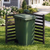 Wooden outdoor privacy fence in black surrounds a green trash can, providing ventilation and decorative coverage.