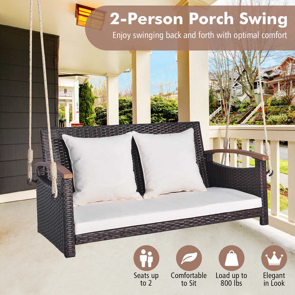 2-person patio rattan porch swing with white cushions, sturdy metal frame, and elegant design for backyard relaxation.