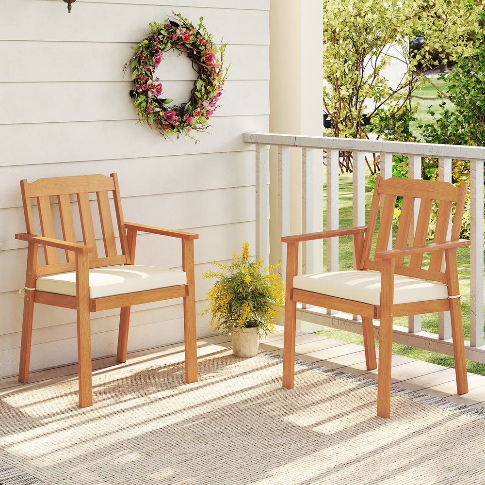 Two acacia wood patio dining chairs with white cushions, perfect for backyard or balcony dining.