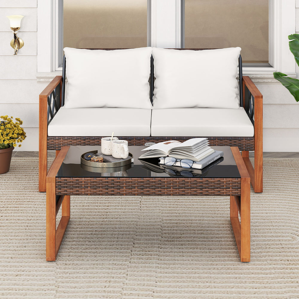Patio PE wicker furniture set featuring a loveseat with white cushions and a glass-top coffee table, ideal for outdoor.