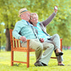 Two people enjoying a selfie on a 2-seat patio wood bench with cozy armrests, perfect for garden relaxation.