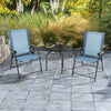 Two blue patio dining chairs with armrests and a metal frame, set on a stone patio, perfect for outdoor relaxation.