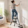 A person uses the 2 step ladder with handrail to paint a wall, showcasing its wide anti-slip pedals and sturdy design.