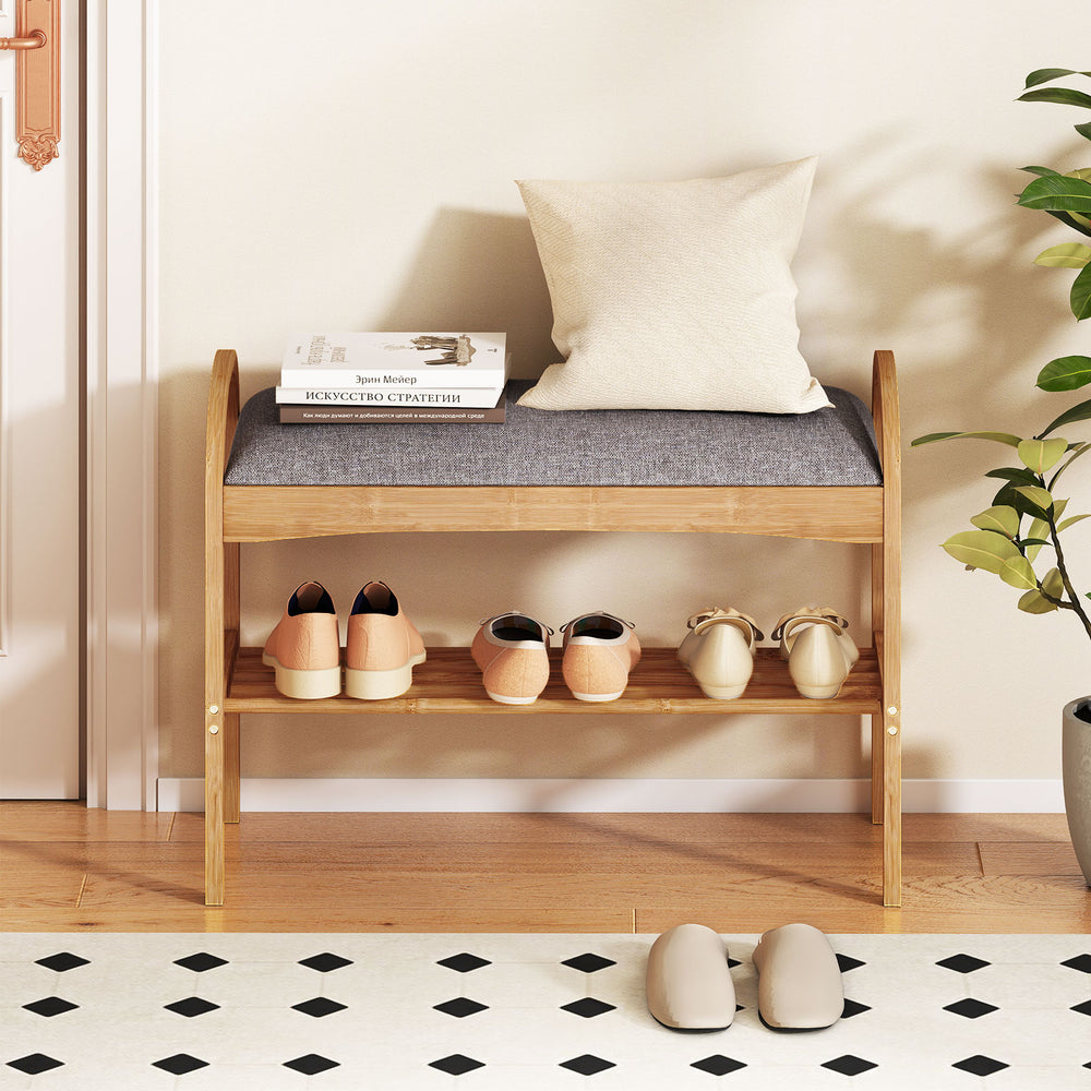 2-tier bamboo shoe bench with gray padded cushion, featuring a slatted shelf for ample shoe storage in entryway.