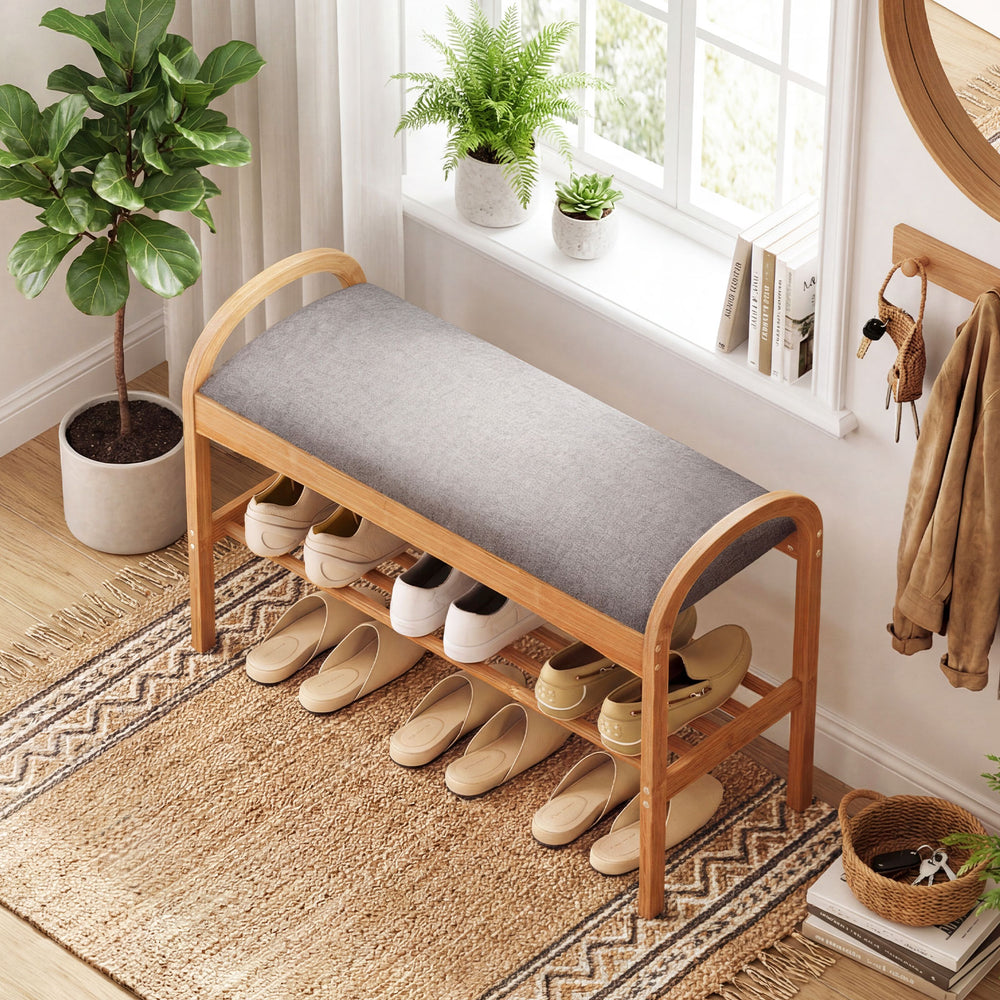 Gray padded cushion on a bamboo shoe bench with slatted shelf, perfect for comfortable shoe storage in hallway or.