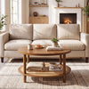 Round rattan coffee table in walnut with a storage shelf, styled in a cozy living room setting.