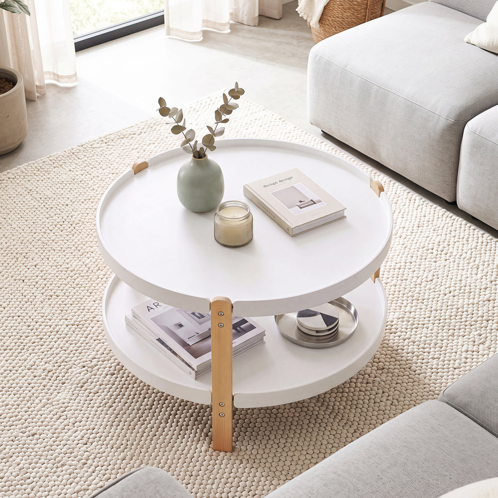 Round 2-tier coffee table in white with solid beech wood legs, perfect for organizing books and decor in the living room.