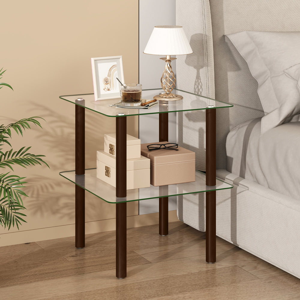 2-tier square end table with a clear tempered glass top and brown rubber wood legs, perfect for bedside storage.