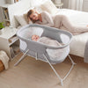 2-in-1 baby bassinet in grey with breathable mesh, featuring rocking motion and foldable design for bedside use.