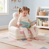 Convertible kids sofa in bunny pattern, pink, used as a lounger for reading, perfect for playroom seating.