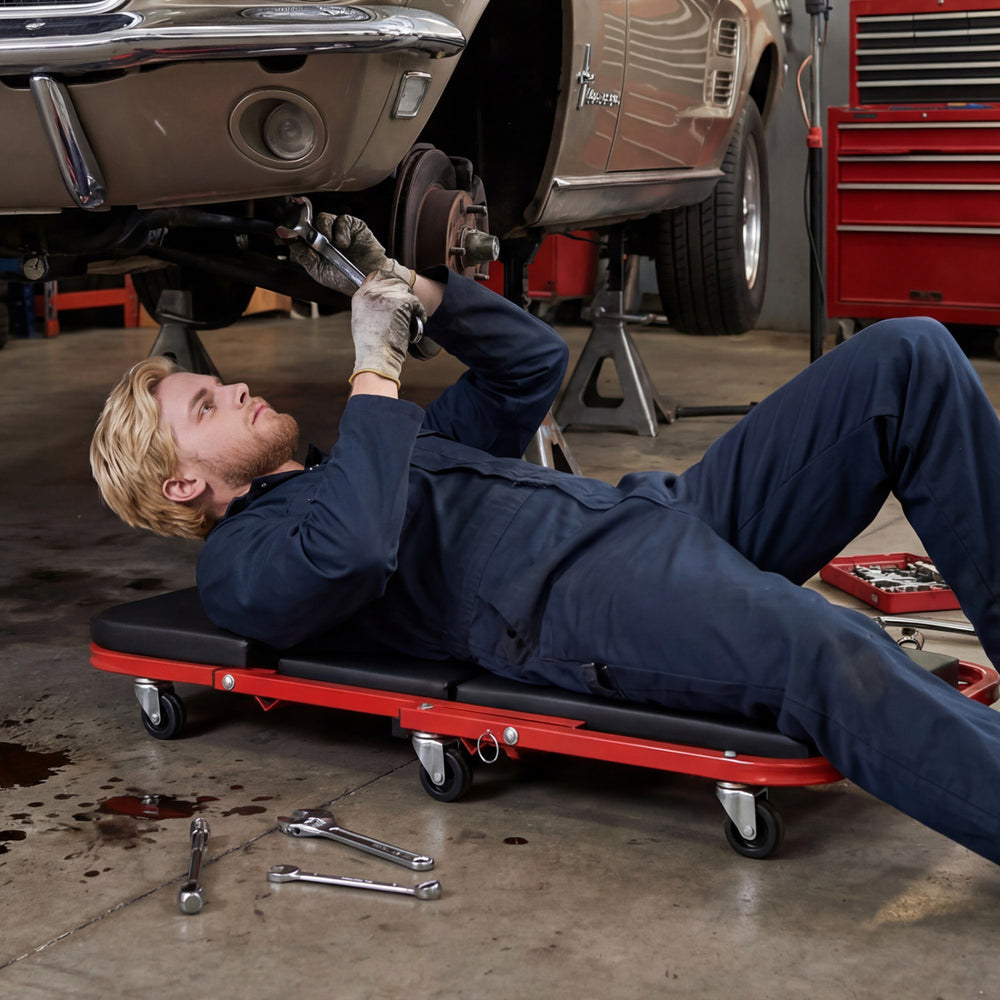 Z-shaped rolling garage stool in creeper mode, featuring a cushioned seat and heavy-duty frame for automotive repair.