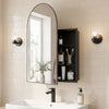 Wall-mounted black storage cabinet with arched mirror and adjustable shelves, perfect for elegant bathroom organization.