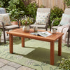 Rectangular outdoor coffee table with slatted top, solid hardwood, and teak oil finish, perfect for backyard use.