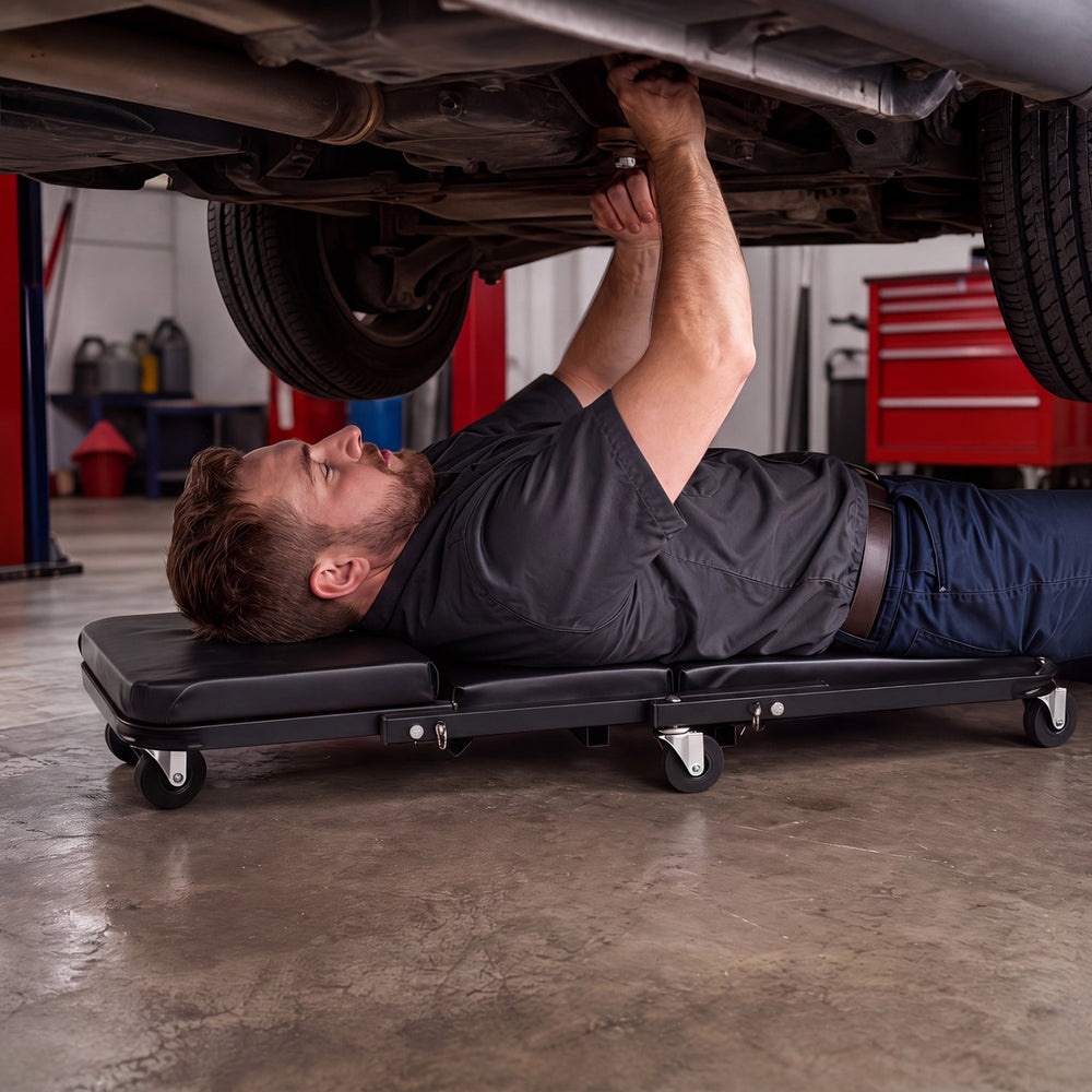 Mechanic creeper with 1.5" thick padded cushion and 6 wheels, ideal for garage and workshop use.