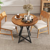 Round dining table with rustic brown wood-grain surface and sturdy metal pedestal base, ideal for dining or living.