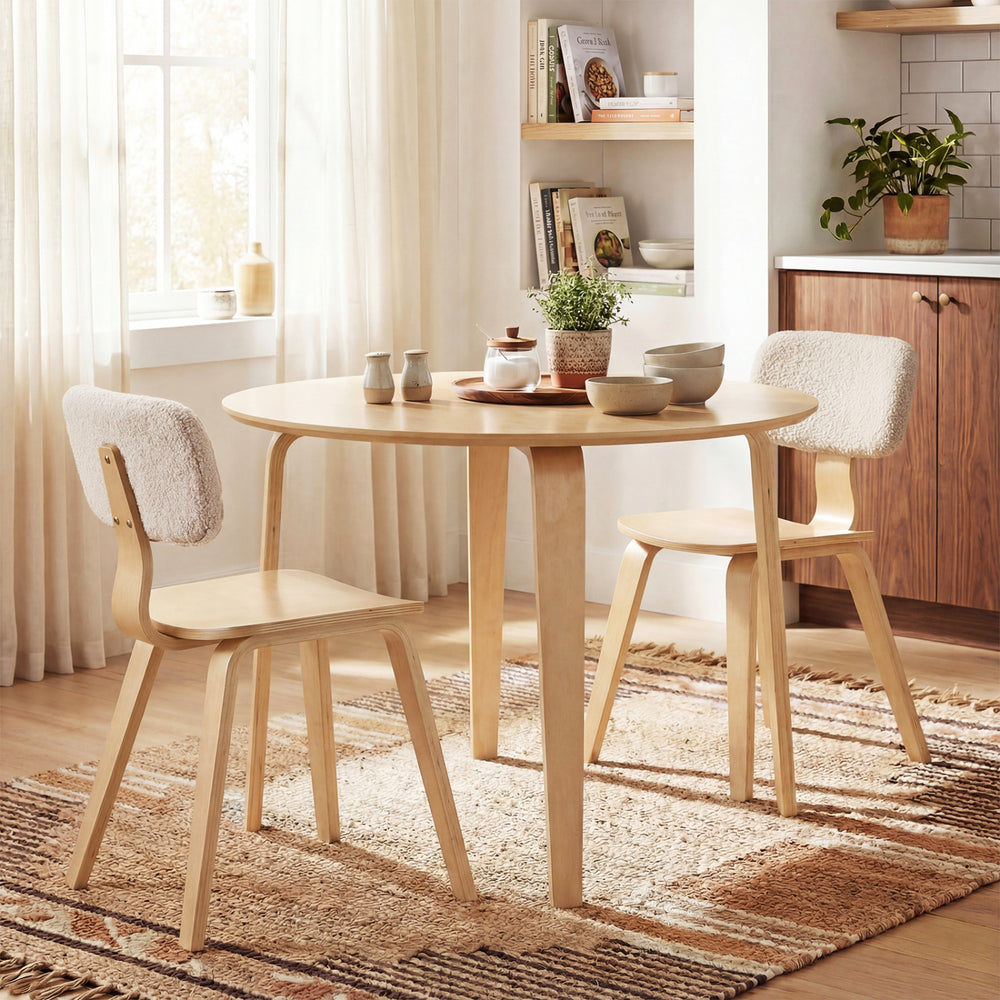 Round dining table with rubber wood legs, designed for small spaces, perfect for 4 people in a cozy kitchen setting.