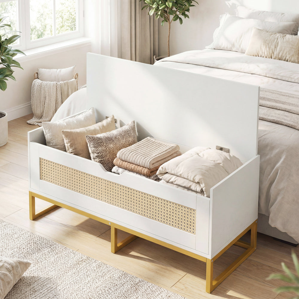 Rattan storage chest with padded seat in white and gold, ideal for entryway or bedroom organization and seating.
