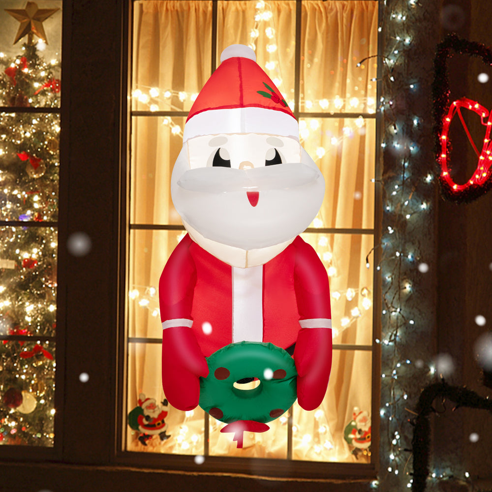 3.3 feet lighted inflatable Santa Claus smiling while holding a wreath, ideal for window decoration during Christmas.