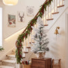 Mini tabletop Christmas tree with snow flocked leaves and pine cones, perfect for festive entry tables and mantels.