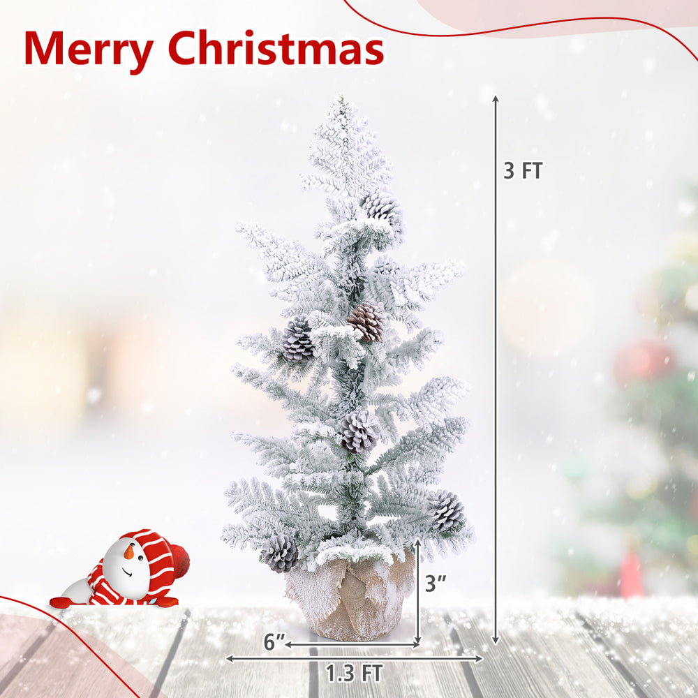 Mini 3FT tabletop Christmas tree features snow flocked PE leaves, 7 pine cones, and a stable linen-wrapped base for festive decor.
