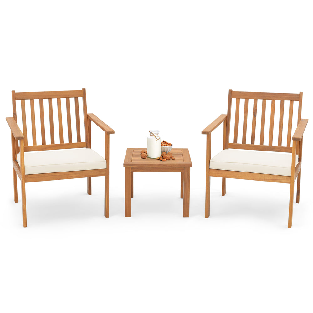 Two acacia wood chairs with soft white cushions and a matching table, perfect for backyard or porch relaxation.