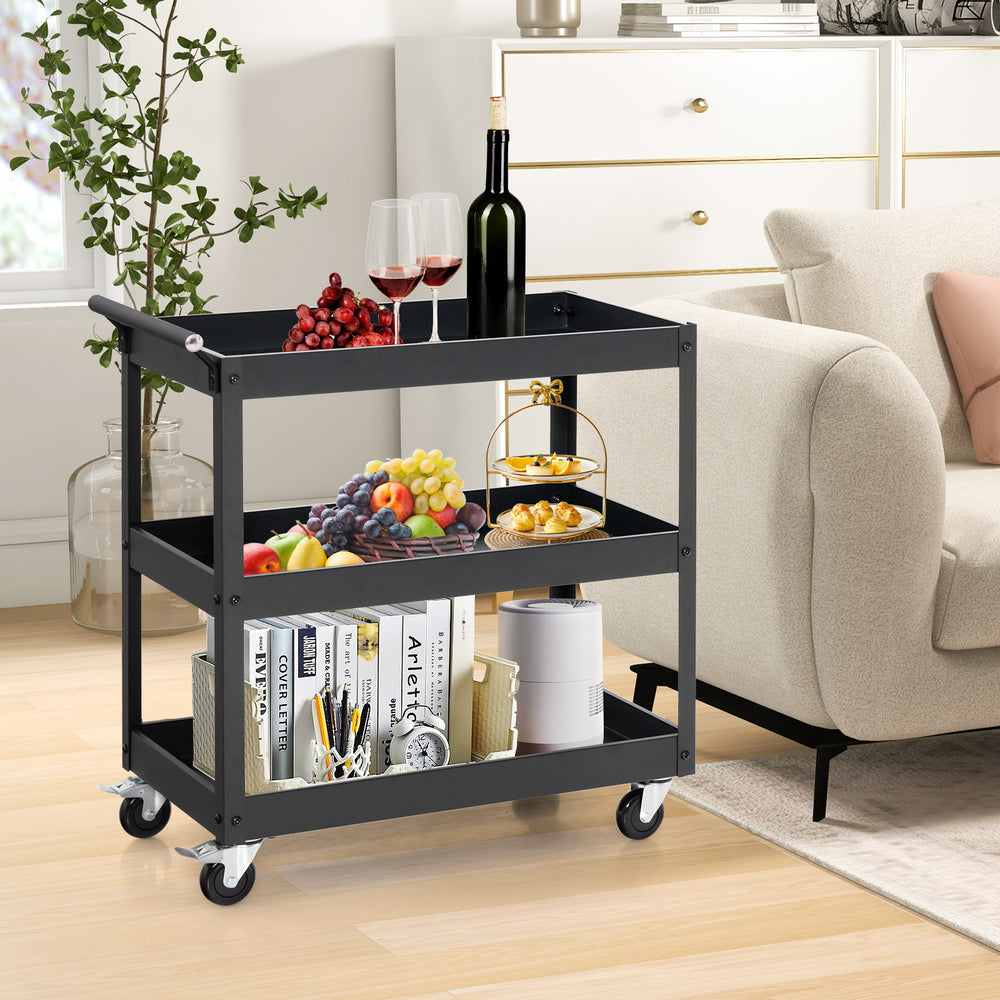 3-tier black metal utility cart with handle, holding wine, fruits, and snacks, ideal for home or office use.