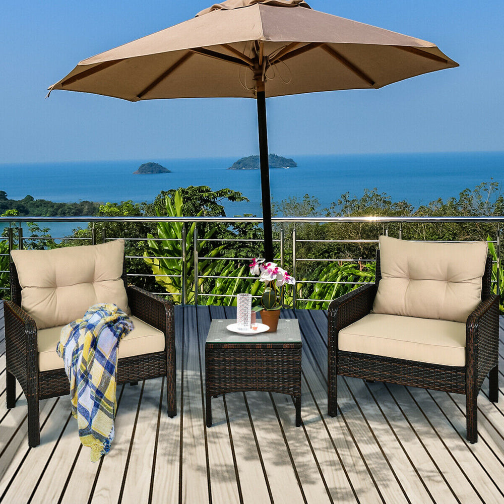 Outdoor patio rattan conversation set with beige cushions, featuring a tempered glass table, perfect for relaxation.