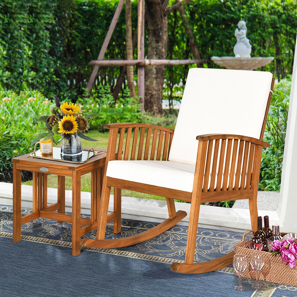 Acacia wood patio rocking chair set with thick cushions, perfect for outdoor relaxation in a garden or backyard.