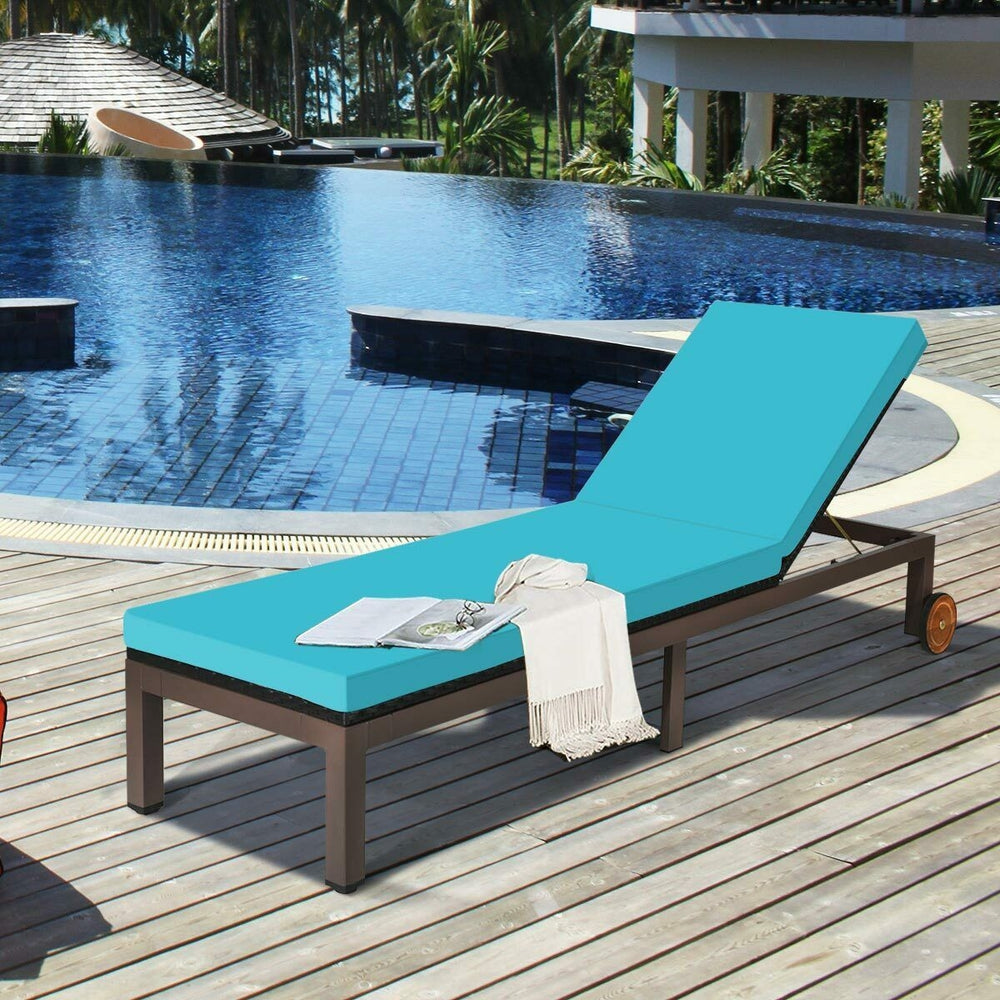 Turquoise outdoor rattan chaise lounge chair showcasing soft cushion and sturdy metal frame, perfect for poolside.