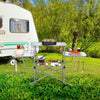 Foldable outdoor BBQ table with aluminum countertop, side shelves, and hooks, ideal for camping and picnics.